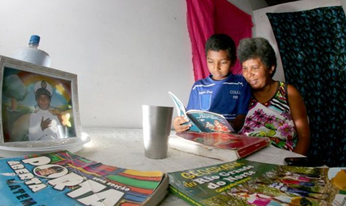 Aos 42 anos, catadora de lixo aprende a ler com filho de 11 anos